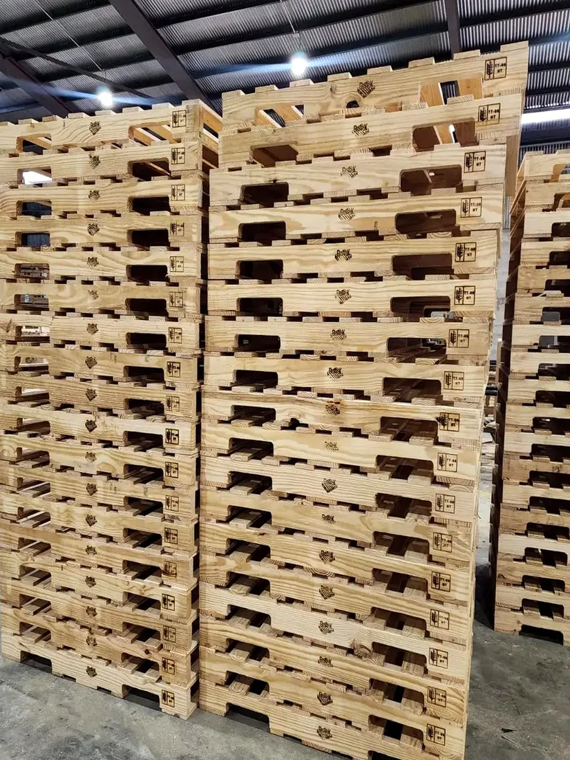 D.A.K branded pallet stacks showing the ISPM 15 TT-08 HT stamp